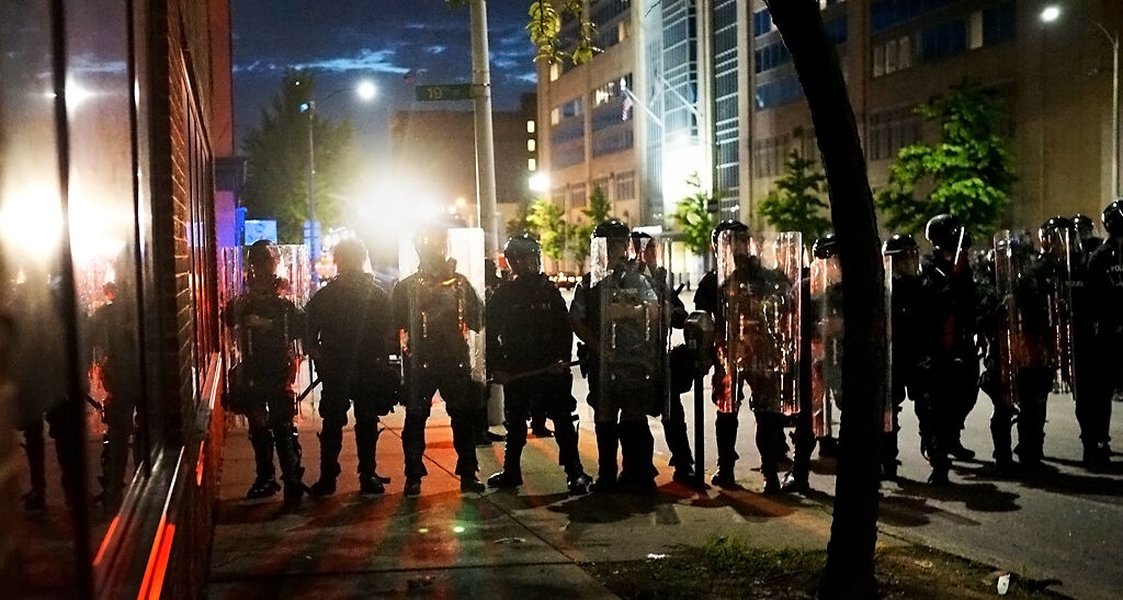 Riot police hold a line near the St. Louis police headquarters Monday